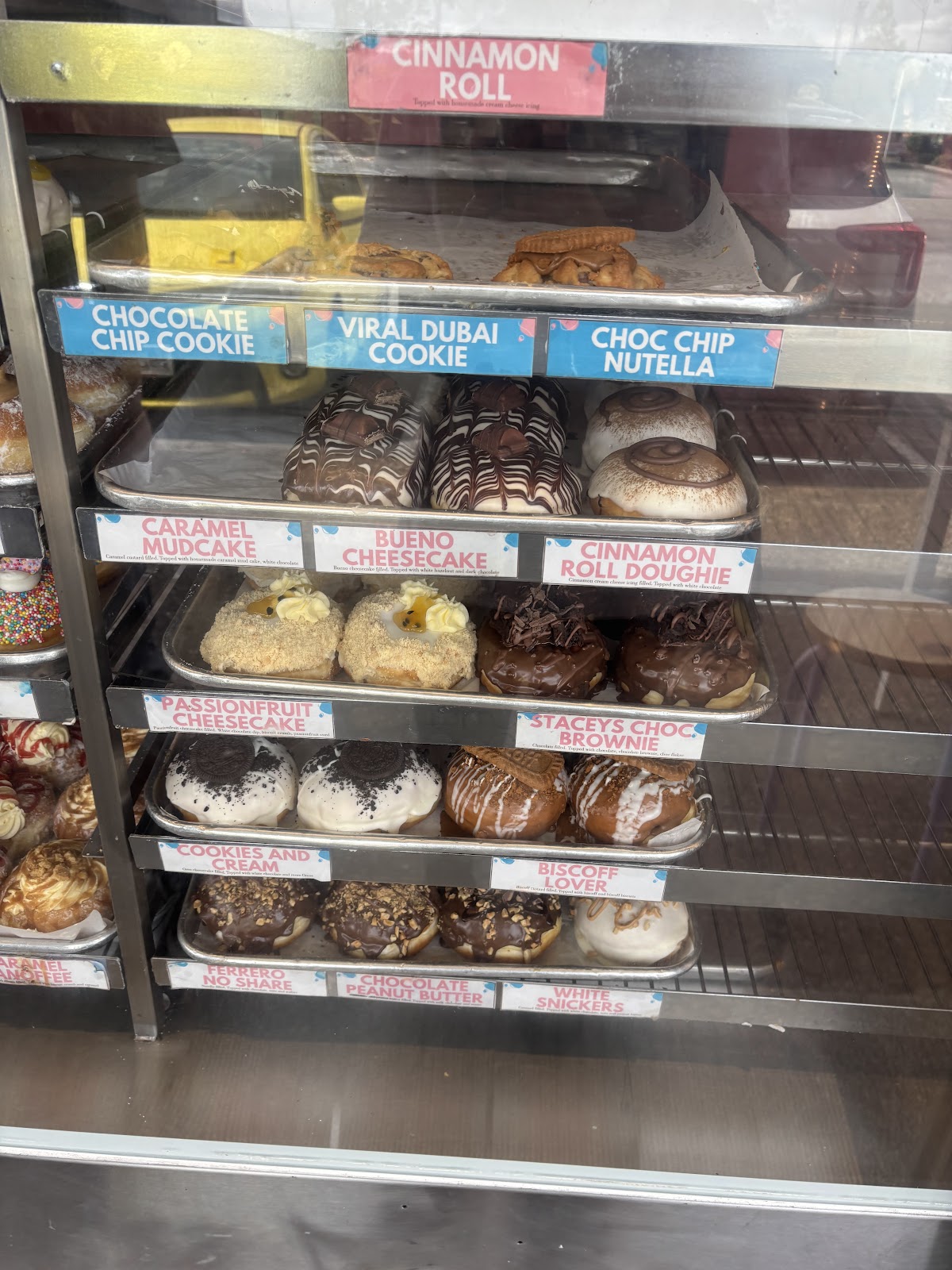 The doughnut display cabinet at Burg World with printed flavour labels